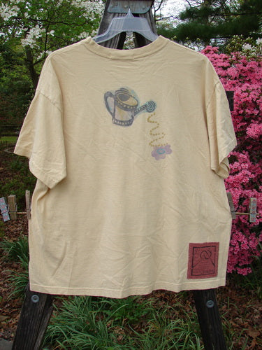 1995 Short Sleeved Tee Garden Water Glint Size 1 featuring a detailed garden watering can drawing, thicker ribbed neckline, drop shoulders, and a slightly shorter boxier shape, made from organic cotton.
