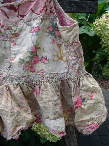 Shabby-chic Magnolia Pearl NWT Quilted Catalina Tank Ragdoll Calico OSFA, featuring a floral-print design with ruffled hemline and distressed accents, displayed on a wooden trellis, exuding vintage charm.