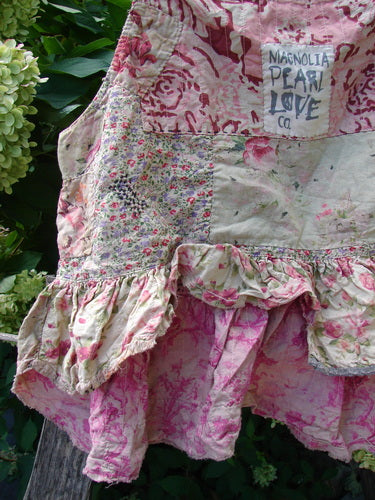 Magnolia Pearl NWT Quilted Catalina Tank Ragdoll Calico OSFA, featuring patchwork floral prints, ruffled hem, and distressed accents, hangs outdoors. Label reads MAGNOLIA PEARL LOVE CO., reflecting vintage-inspired charm.