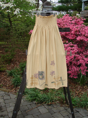 1995 Smocked Skirt Garden Tea Glint Size 2 hanging on a clothesline, featuring a detailed smocked waistband and a full, flowing silhouette with painted garden tea motif.