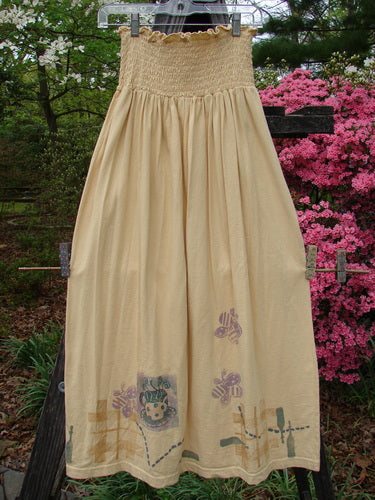 1995 Smocked Skirt Garden Tea Glint Size 2 displayed on a clothesline, featuring a bee design and delicate smocking, part of the Spring Collection, showcasing vintage charm and flowing full hips.