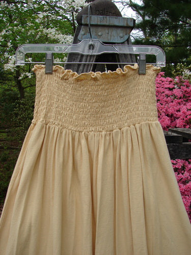 1995 Smocked Skirt Garden Tea Glint Size 2 displayed on a swing, showcasing its full flow, smocked waist, and ruffled top, epitomizing vintage elegance from BlueFishFinder's curated collection.