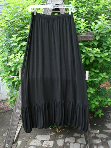 2000 Rayon Lycra Bubble Skirt Unpainted Black Size 1 hanging on a clothes rack, showcasing its gathered bubble bottom, full elastic waistline, and tapered hemline.