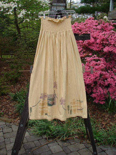 1995 Smocked Skirt Garden Tea Glint Size 2 displayed on a clothes rack, featuring a floral design and a flowy, full hip measurement with a tiny ruffled top.