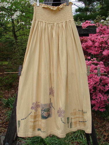 1995 Smocked Skirt Garden Tea Glint Size 2 hanging on a clothesline, displaying a flowing, patterned design with a smocked waistband and ruffled top.