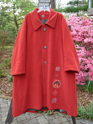 1999 Patched Woven Overcoat Tomato Altered Size 0 on a rack, showcasing vintage-inspired design with oversized buttons, hand-blocked patches, deep inseam pockets, and foldable lower sleeves.