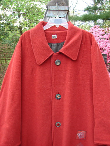 1999 Patched Woven Overcoat Tomato Altered Size 0 displayed on a hanger, showcasing its vintage-inspired design with oversized buttons, hand-blocked patches, and a swinging A-line shape.