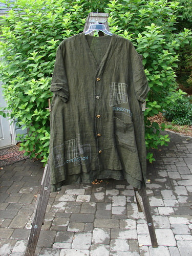 2000 Cross Dye Linen Downtown Jacket Directional Oregano Size 2 on wooden stand, showcasing ceramic glazed buttons, V-shaped neckline, shirt tail hemline, and oversized exterior pocket.