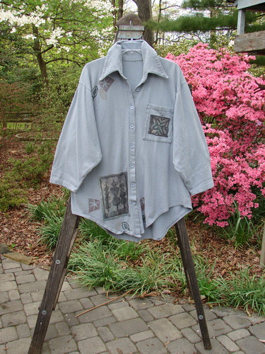 1994 Reprocessed Work Shirt Topiary Moon Solstice Blue OSFA displayed on a wooden ladder, showcasing a painted breast pocket, pointed collar, drop shoulders, round shirttail, and Blue Fish buttons.