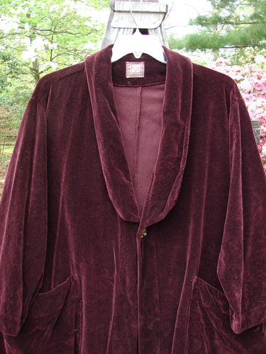 1999 Patched Velveteen Poet's Coat Holiday Deep Burgundy Size 1 displayed on a mannequin, showcasing oversized button closures, a folded collar, two front pockets, and colorful patches on a varying hemline.