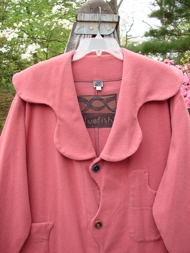 2000 Patched Wool Nora Coat Pastel Geranium Size 0 displayed outdoors on a swing, showcasing its unique scalloped buttons, collar, and two front pockets with distinctive scalloped lines.