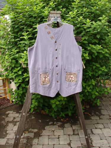 1996 Denim Visionary Vest Travel Stone Stratus Size 1, displayed on a rack. The vest features a V-shaped neckline, metal front buttons, riveted pockets, a rear buckle draw tab, and a scooped backline.