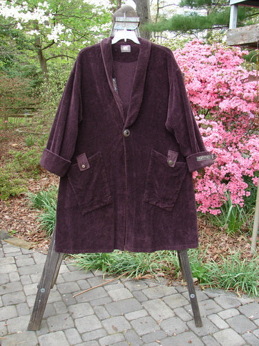 1999 Patched Chenille Angle Pocket Jacket in Deep Burgundy, displayed on a rack, showcasing its oversized vintage buttons, diagonal front pockets, and unique patched collar.