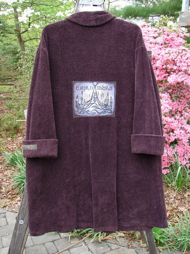 1999 Patched Chenille Angle Pocket Jacket in Deep Burgundy, featuring oversized vintage button closures, diagonal floppy pockets, and a giant rare patch with Holiday Gates theme, displayed on a brick surface.