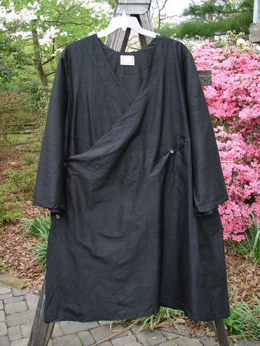 2000 Shaunting Silk Slant Wrap Jacket Unpainted Deep Black Size 2, displayed outdoors on a stand. Features include wrap style, wider sleeves, diagonal button accents, and hidden pockets.