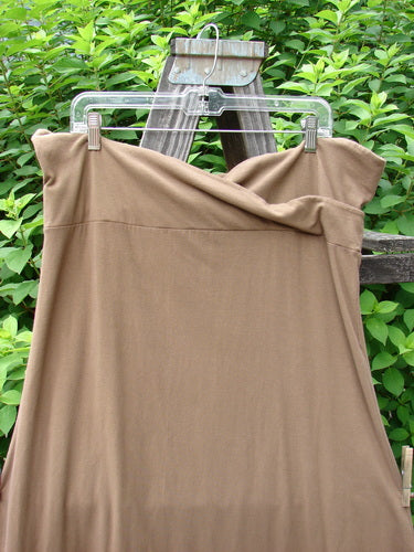 Barclay Cotton Lycra Fold Over Bottom Bell Skirt Unpainted Coco Size 2 displayed on a clothesline, highlighting its cross-over front banded waistline and lower bell accent, showcasing its flowing, pocketless design.