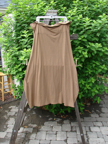 Barclay Cotton Lycra Fold Over Bottom Bell Skirt Unpainted Coco Size 2 on a wooden rack, highlighting its cross-over front banded waistline and lower bell accent, displayed in perfect condition.