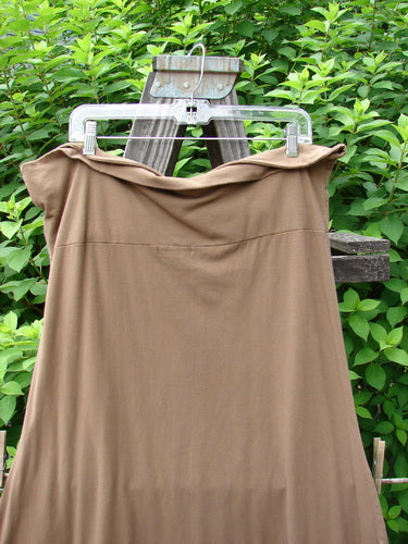 Barclay Cotton Lycra Fold Over Bottom Bell Skirt Unpainted Coco Size 2 hanging on a clothes rack, showcasing a cross-over front banded waistline and lower bell accent.