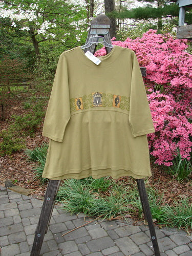 1999 NWT Interlock Scoop Top Celtic Holiday Leaf Size 2 displayed on a wooden hanger, showcasing a rounded neckline, scooped empire waistline, and signature Blue Fish patch.