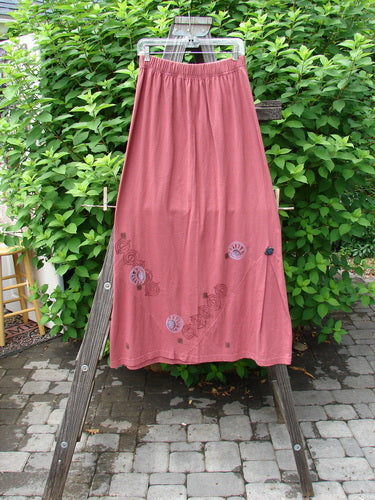 1996 Dubuffet Skirt Tumble Stone Ember Size 2 displayed on a wooden stand, showcasing its A-line design with triangular side panels, pleats, and elastic waistline.