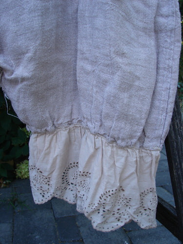 Close-up of Magnolia Pearl Heavy Gauze Embroidered Signature Farm Love Overall Natural OSFA, showing broderie anglaise cotton ruffle and gathered linen panel, highlighting its vintage, handmade appearance.