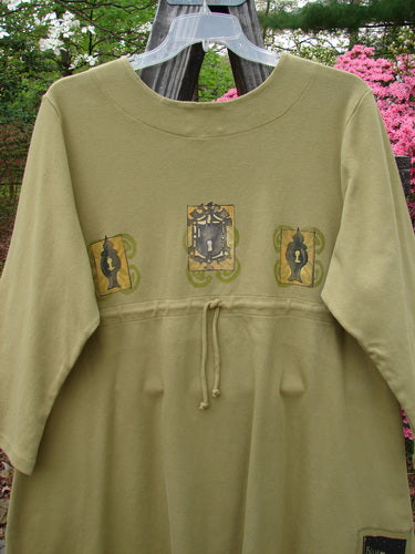 1999 NWT Interlock Scoop Top Celtic Holiday Leaf Size 2, featuring a green shirt with a rounded neckline, downward scooped empire waistline, draw cord back, and Celtic-themed design.
