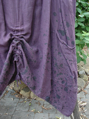 Close-up of Barclay Linen Two Pocket Pull Up Jumper Berry Vine Red Plum Size 2, showcasing its vertical seams, softly dipped V-neckline, and double exterior pockets, highlighting its elegant drape and feminine shape.