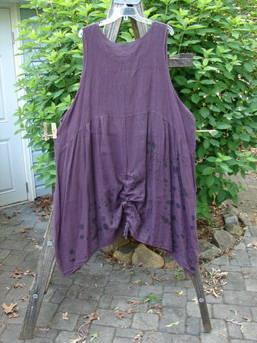 Barclay Linen Two Pocket Pull Up Jumper Berry Vine Red Plum Size 2 hanging outdoors, showcasing its A-line shape, softly dipped V-neckline, and double exterior pockets, capturing its elegant drape and feminine design.