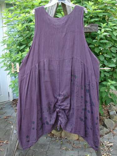 Barclay Linen Two Pocket Pull Up Jumper Berry Vine Red Plum Size 2 hangs elegantly on a clothes rack, showcasing its vertical seams, softly dipped V-neckline, and double exterior pockets, embodying Bluefishfinder.com's vintage charm.