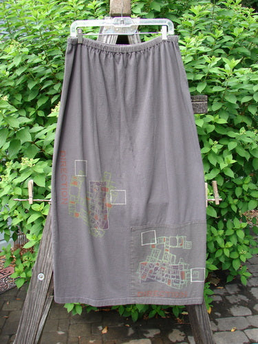 2000 Block Skirt Directional Iron Size 2, hanging on a clothesline, features a unique painted design on organic cotton with a flared lower shape and a professionally replaced larger elastic waistband.