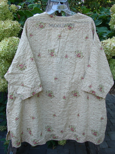 Magnolia Pearl European Cotton Quilted Hi Low Frances Top Vintage Rose OSFA, displayed outdoors, features cream cotton with rosebud print, hand-style quilting, kimono cut, mid-length sleeves, and deep side inseam pockets.