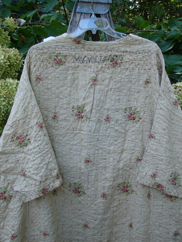 Magnolia Pearl European Cotton Quilted Hi Low Frances Top Vintage Rose OSFA displayed outdoors, featuring a kimono-inspired cut with rose-bud print, wide sleeves, and signature Magnolia Flora label across the back neck.