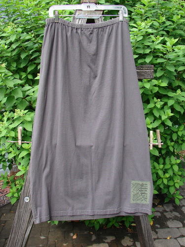 2000 Block Skirt Directional Iron Size 2 hanging outdoors, showcasing its unique painted design, slightly flared lower shape, and professionally replaced larger elastic waistband. Made from organic cotton.