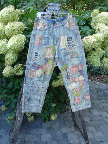 Magnolia Pearl NWT Denim Heavily Patched Miner Jean Garden Patch Washed Indigo OSFA with floral-patterned patches and raw edges, draped over a wooden ladder amidst a garden setting.