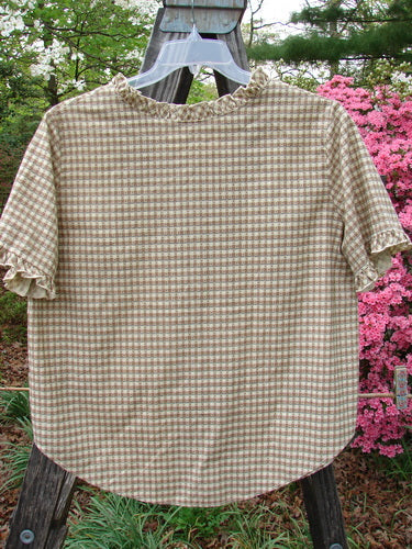 1996 Woven Boardwalk Top Unpainted White Pine Gingham Size 2, featuring gathered ruffle neck and sleeve lines, rounded hem, and bust darts displayed on a clothes rack.