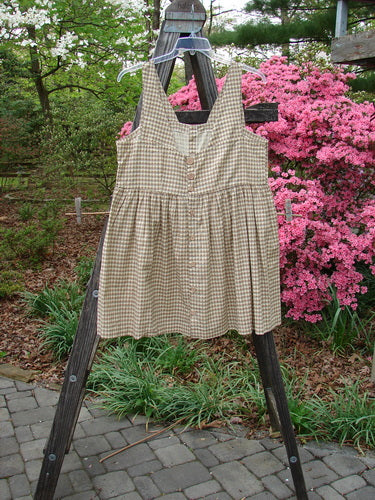 1996 Woven Roadside Jumper Unpainted White Pine Gingham Size 2, displayed on a wooden stand outdoors, featuring wooden buttons, a square neckline, and a pleated, blousy lower section.