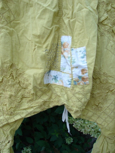 Magnolia Pearl NWT Embroidered Khloe Bloomer in Golden Daffodil, showcasing a light yellow-green fabric with floral embroidery and a floral patch, perfect for expressing individuality with unique hand-mended details.