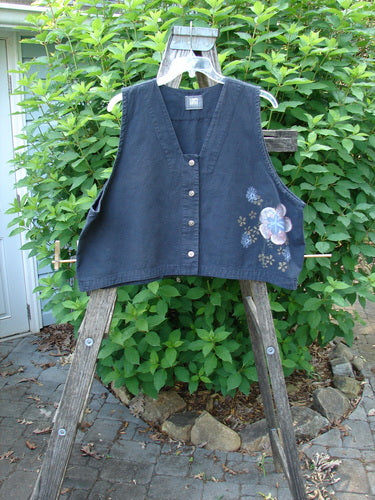 2000 Parachute Cross Stitch Vest Floral Black Size 2 showcased on a wooden stand, featuring a uniquely squared neckline, four metal buttons, crop length, super flared shape, and vibrant floral design.