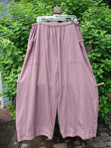 Barclay Batiste Bottom Double Flutter Pant Unpainted Dusty Rose Size 2: A pair of pants on a clothesline made from medium weight organic cotton, featuring a full elastic waistband, double layer flutter batiste accents, deep front entry pockets, and a relaxed fit.