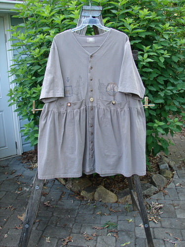 Close-up of the 1999 Vintage Button Dress Butterfly Circle Shale Size 2, showcasing tiny front buttons, higher pockets, gathered pleats, and dual rear draw cords for a unique fit.