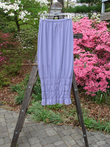 2000 Rings of Saturn Skirt Unpainted Twilight Size 2 displayed on a wooden ladder, showcasing its full skinny larger elastic waistline, tapered and pegged lower, and continuous stretchy lower smocking.