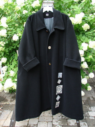 1999 Patched Woven Overcoat Black Size 2: A black wool overcoat featuring hand-sewn patches, three oversized buttons, deep inseam pockets, and foldable sleeves, showcasing vintage-inspired design from the 1999 Fall Collection.