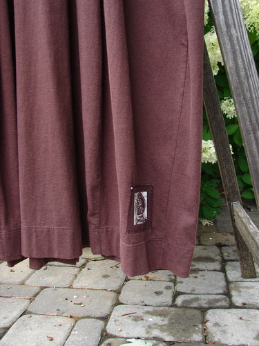 Close-up of the 1998 Merino Pria Dress Unpainted Raisin Size 1, highlighting its fine knit texture, ribbed neckline, and distinctive diamond cut buttons along the sectional bell-shaped seams.