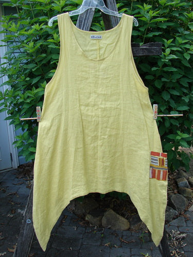 Barclay Linen Single Side Pocket Pinafore Geos Sunshine Size 1 hanging outdoors, showcasing its A-line flair, deeper scoop neckline, and distinctive single drop side wrap pocket.