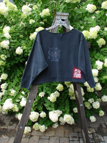 1997 Boxy Top with logo on wooden ladder, floral design, outdoor setting