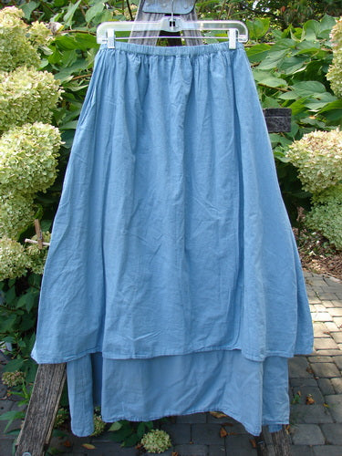 Barclay NWT Batiste Layer Skirt Unpainted Green Sea Size 0 displayed on a clear hanger against wooden trellis, showcasing its tiered design and full replaced elastic waist, reflecting BlueFishFinder.com's vintage style.