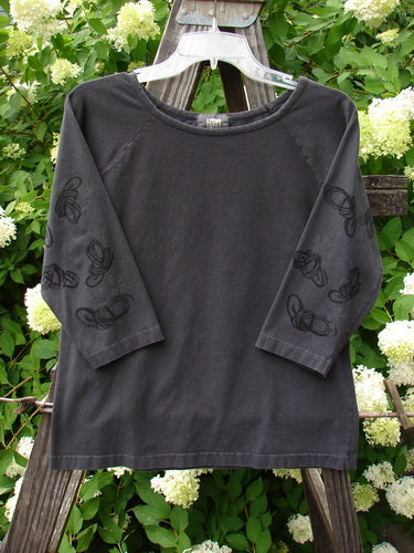 2001 Raglan Tee Top Celtic Knot Licorice Tiny Size 2 with 3/4 black sleeves, shallow rolled neckline, and playful paint design, showcasing unique diagonal shoulder seam and fitted style.