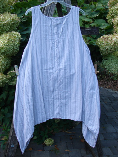 Barclay NWT Percale Hado Shift in Stripe Smoke Pearl Size 1, featuring a handkerchief-style hem and deep scoop neckline, displayed on a hanger against a natural garden setting.