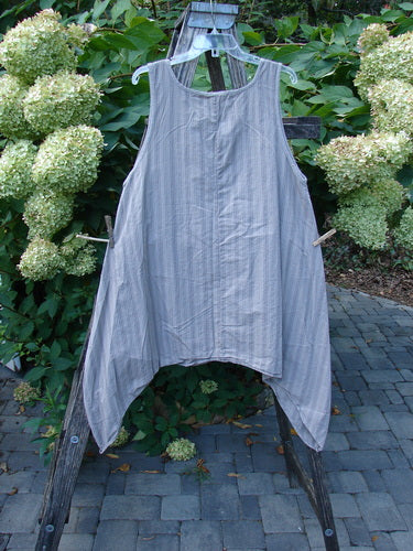Barclay NWT Percale Hado Shift in Stripe Moon Rock Sand Size 1, displayed on a hanger outdoors, features an asymmetrical hem and a loose-fitting, sleeveless design with vertical pinstripes.