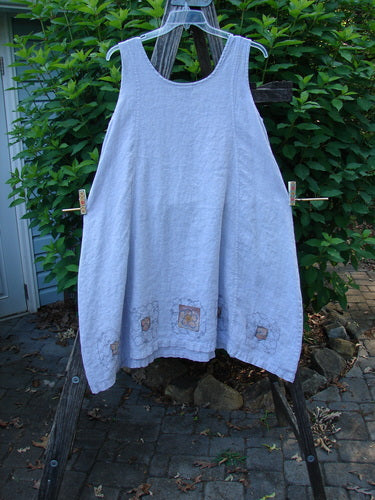 Barclay Linen Pocket Pinafore Mosaic Floral Lavender Size 0 features an A-line flair with mosaic floral pockets and a scoop neckline. Displayed on a clothesline, highlighting its lightweight linen and sectional panels.
